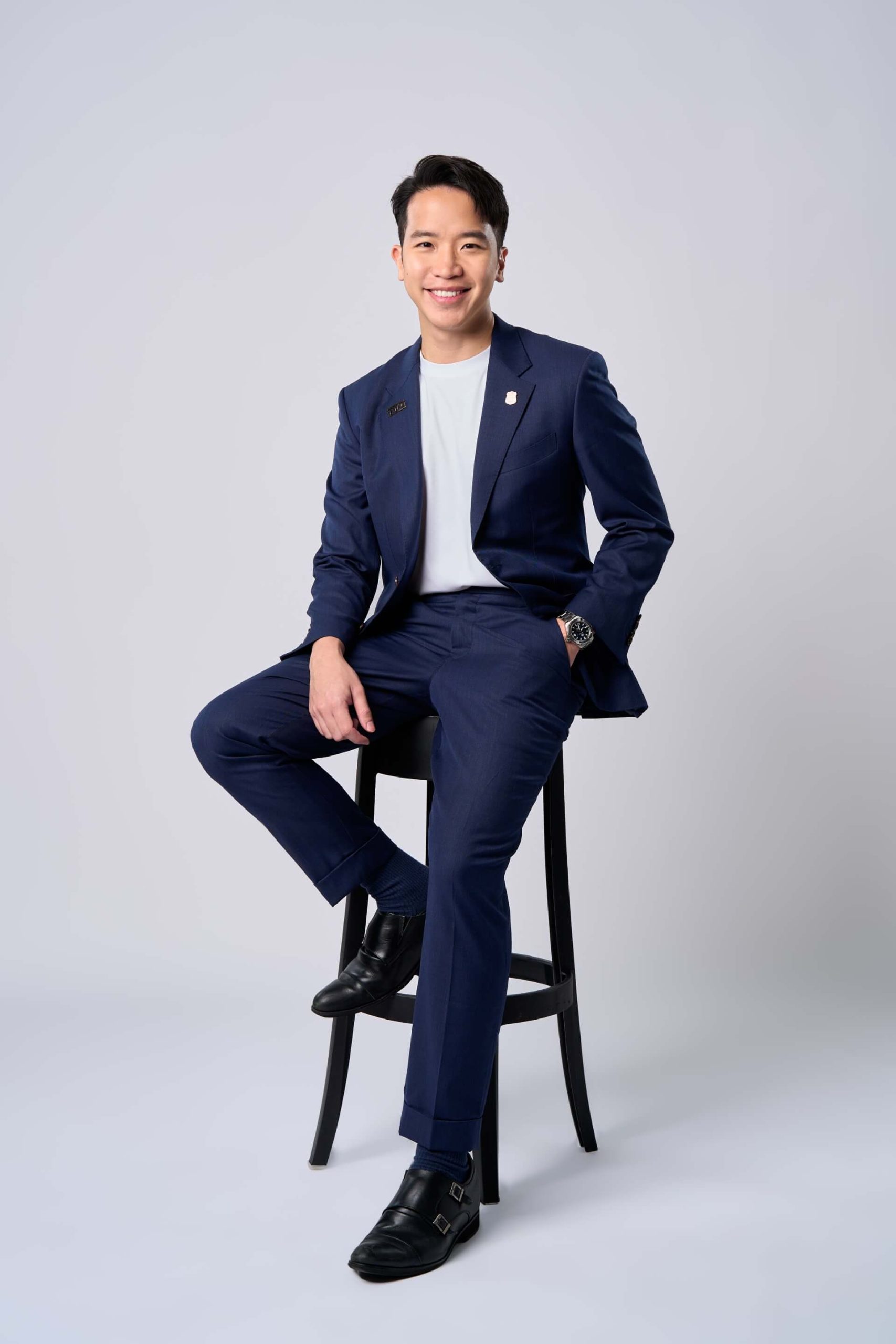 Wilfred Wong seated in a navy suit